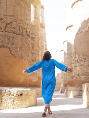 Rear view of a female tourist enjoying a tour at the Great Temple of Amun in Karnak, Egypt.